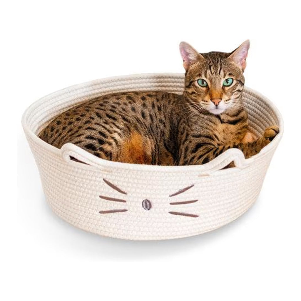 Tabby cat resting in a white Catstages Bed & Basket Retreat rope basket bed with cat-ear handles and an embroidered cat face.