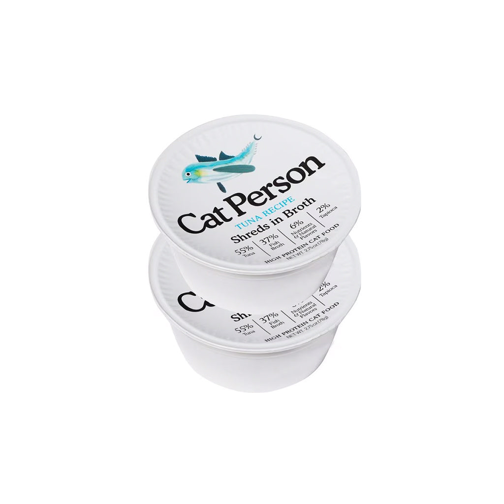 Two stacked white tubs of Cat Person Tuna Recipe shreds in broth wet cat food, with teal fish illustrations on the lids.