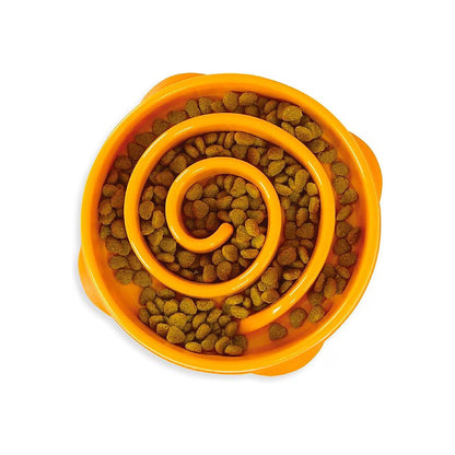 Top view of an orange Outward Hound Fun Feeder Slo Bowl with a raised spiral divider and kibble in the curved channels.