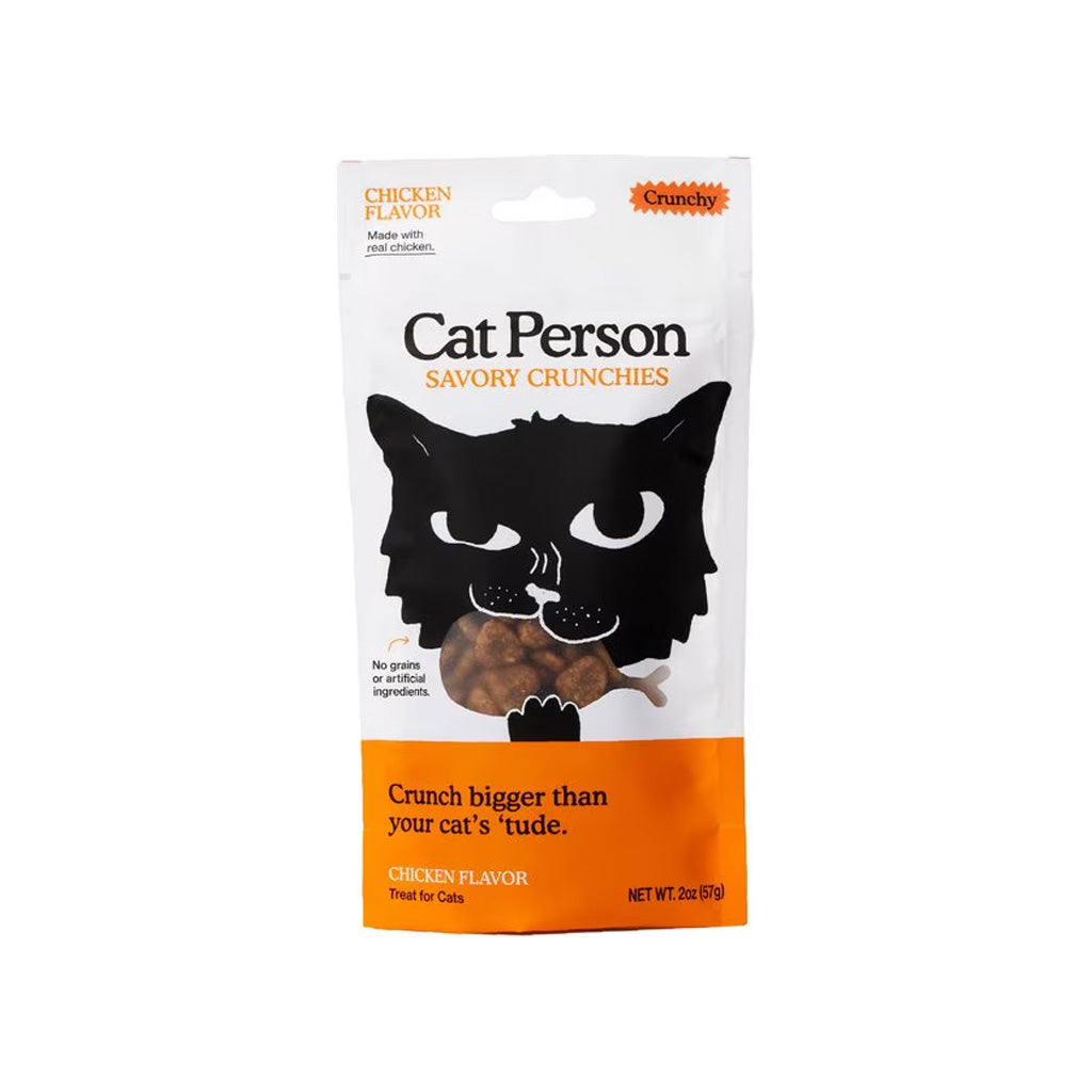 Front of a white and orange 2 oz Cat Person Chicken Flavor Savory Crunchies cat treat bag, with a black cat illustration and fish-shaped treats.
