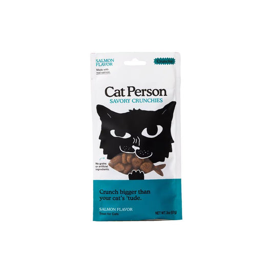 Front of a white and teal 2 oz Cat Person Salmon Flavor Savory Crunchies cat treat bag, with a black cat illustration and fish-shaped treats.