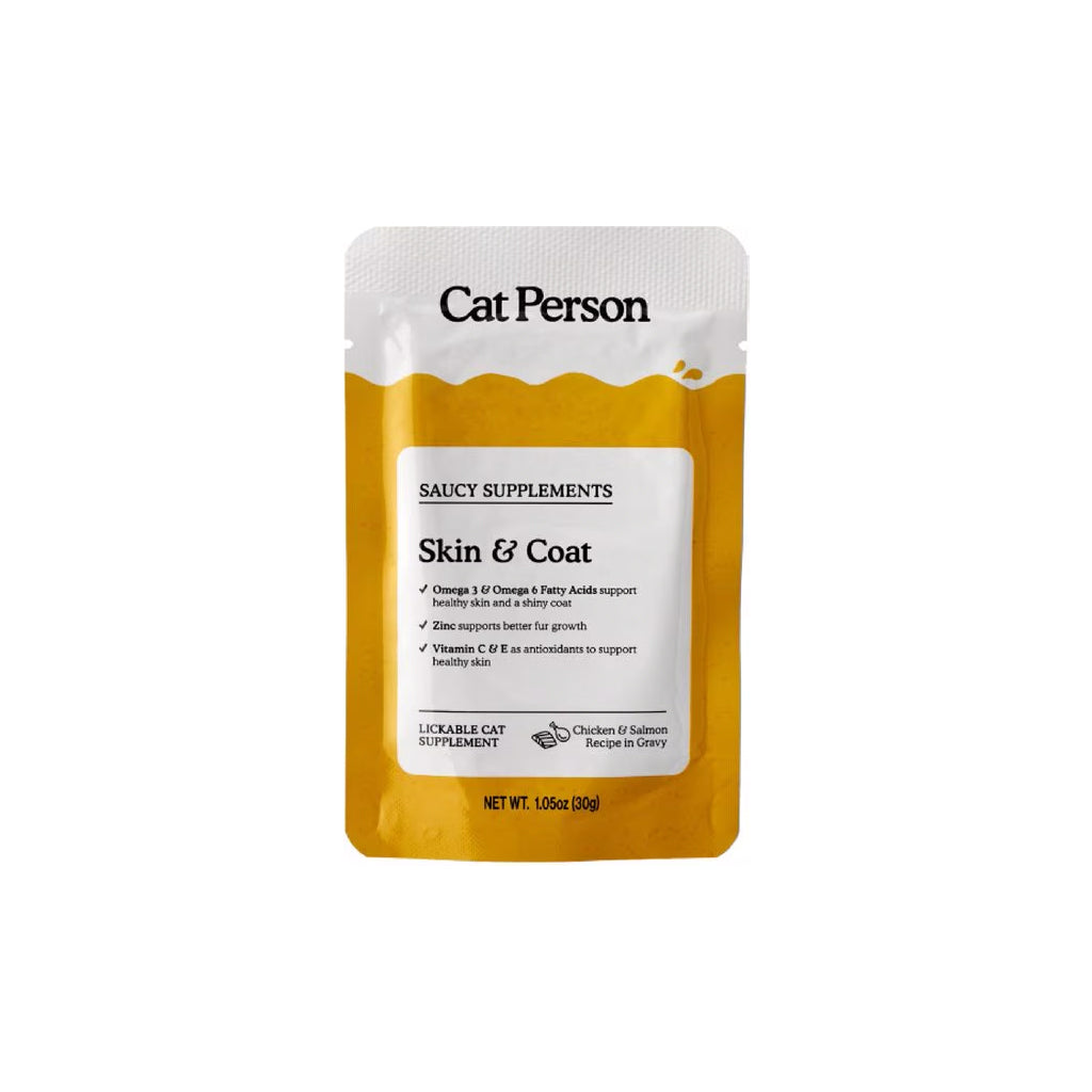 Front of a yellow and white 1.05 oz Cat Person Skin & Coat Saucy Supplements pouch, chicken and salmon recipe in gravy for cats.