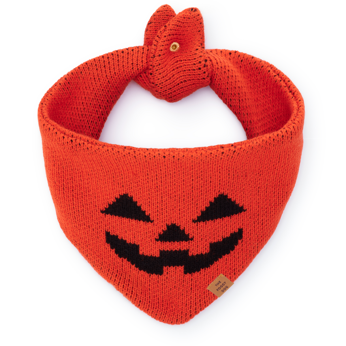 The Foggy Dog Jack-o’-Lantern Knit dog bandana in orange with a black pumpkin face and button closure