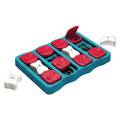 Blue Dog Brick puzzle with red flip-top sliding compartments, removable white bone covers, and treats visible in the open spaces.