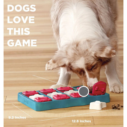 Merle dog sniffing the blue Dog Brick puzzle with red lids and white bone covers; dimension labels show 12.8 by 9.2 inches.