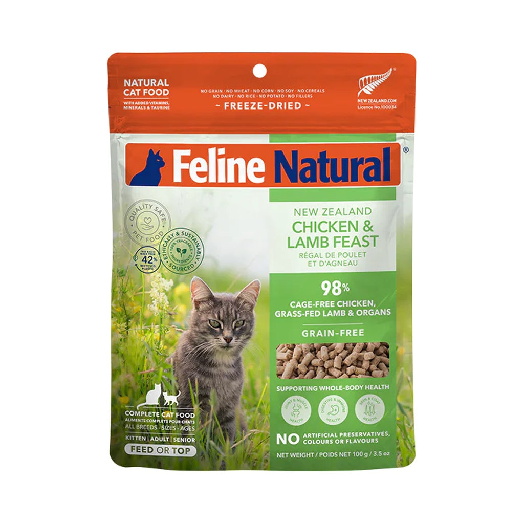 Front of a Feline Natural Chicken & Lamb Feast freeze-dried cat food pouch, with an orange top, green label and cat illustration.