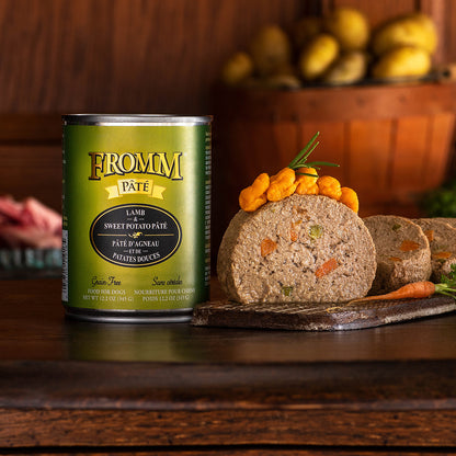 Fromm Lamb & Sweet Potato Pâté can beside slices of pâté topped with orange vegetables on a wooden board
