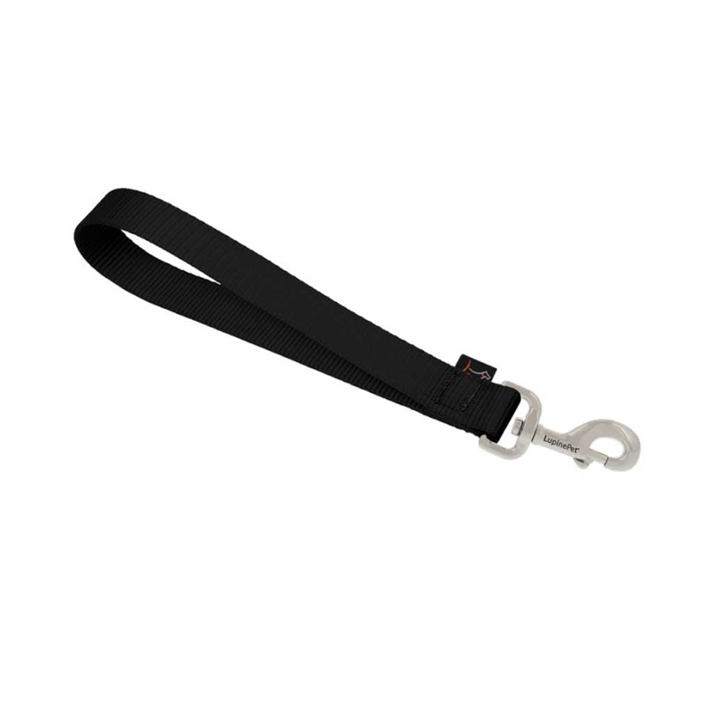 Lupine Pet black nylon training tab showing the loop handle, reinforced stitching, and metal snap.