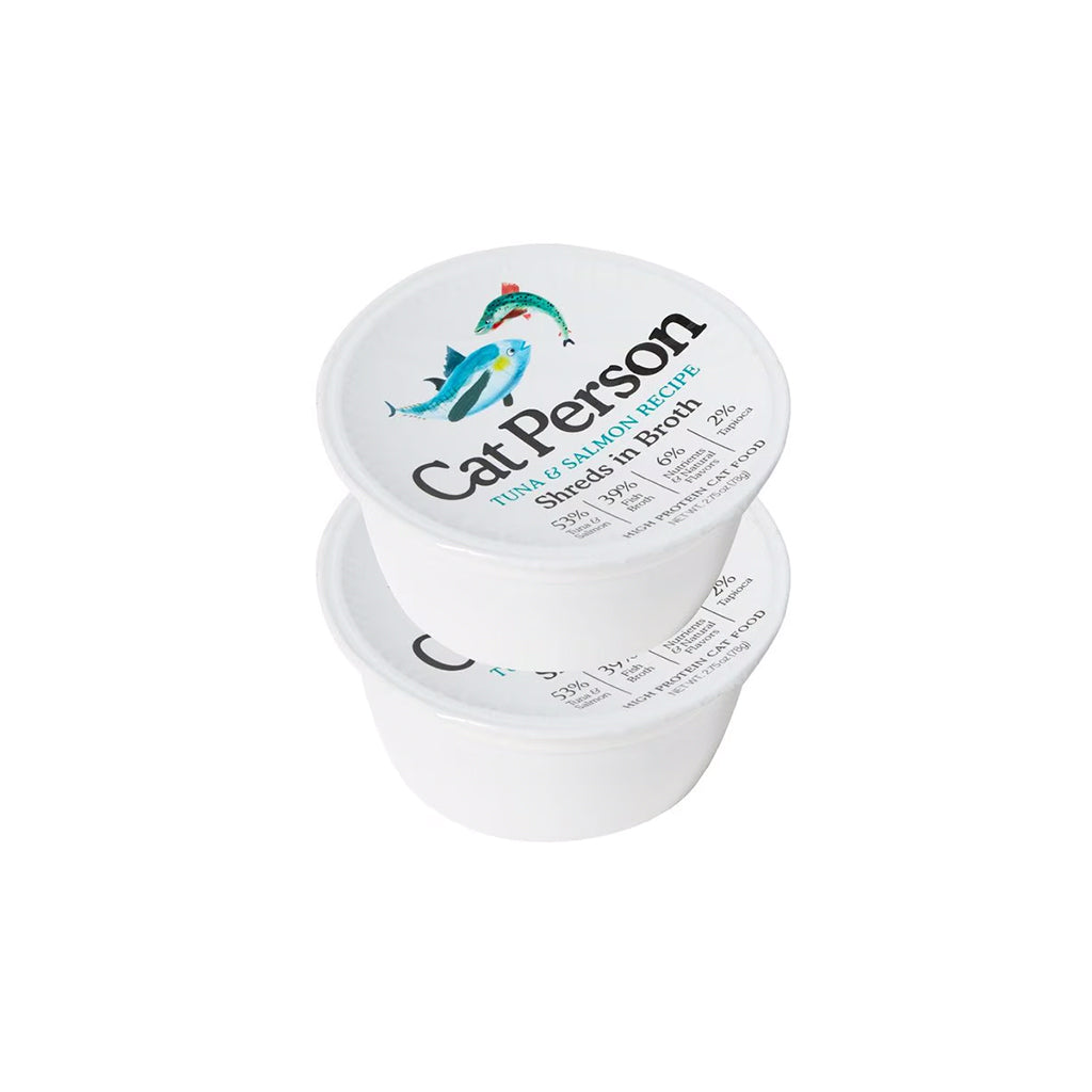 Two stacked white tubs of Cat Person Tuna & Salmon Recipe shreds in broth wet cat food, with fish illustrations on the lids.