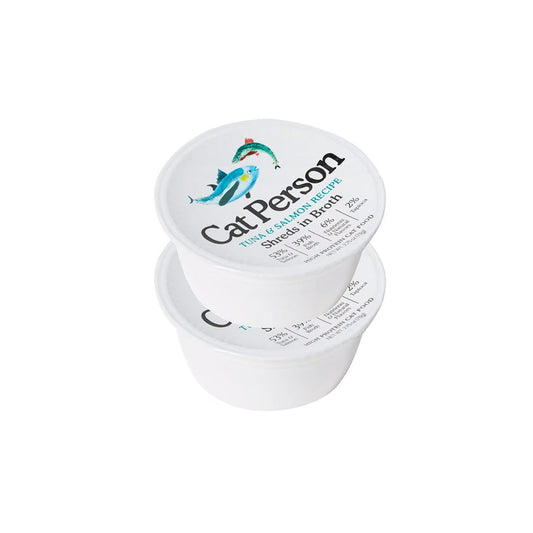 Two stacked white tubs of Cat Person Tuna & Salmon Recipe shreds in broth wet cat food, with fish illustrations on the lids.