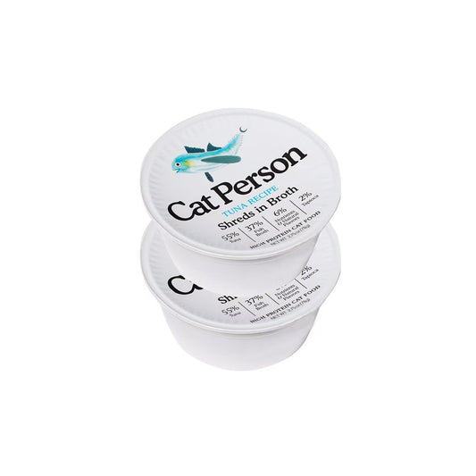 Two stacked white tubs of Cat Person Tuna Recipe shreds in broth wet cat food, with teal fish illustrations on the lids.